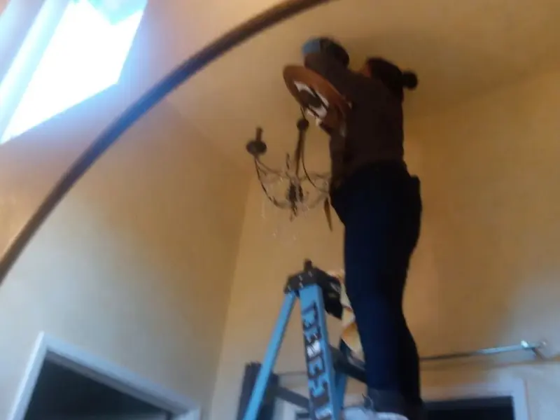 Electrician installing a chandelier in a Sheffield residence